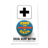 A round blue pinback button that reads END THE GEN0CIDE IN GAZA in yellow & orange bold text. The pinback button is attached to a SOCIAL ALERT BUTTON backing card. 