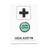 Round enamel pin that says CRUISE CONTROL on a Social Alert pin backing card