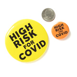 Big round neon yellow pinback button reads HIGH RISK FOR COVID in bold black text. To the right is a quarter and a 1.25" button for scale that reads HIGH RISK FOR COVID in orange, available seperatly.
