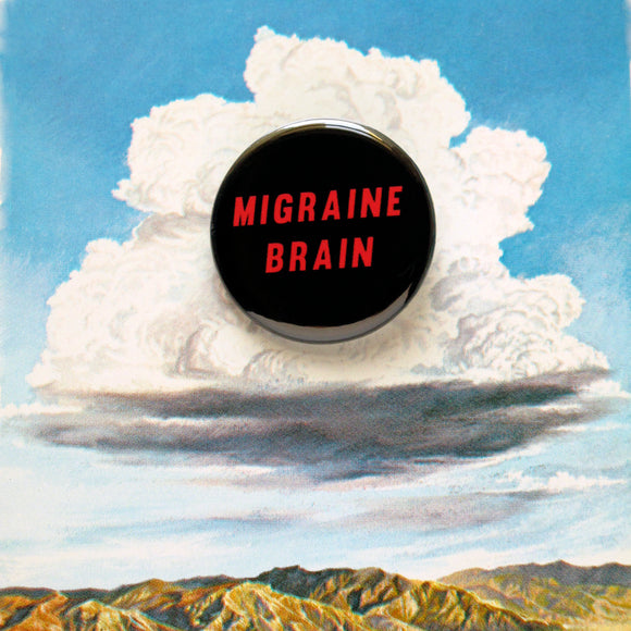 A round black pinback button that reads MIGRAINE BRAIN in red text on two lines. Button is on a vintage illustration of a fluffy cloud above mountains.