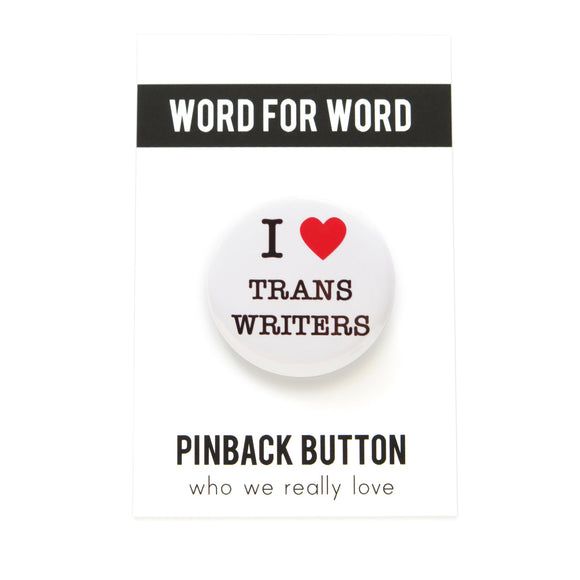 Round white pinback button with a bright read heart that reads I HEART TRANS WRITERS in classic black type. Button is on a white backing card, with a black band at the top with WORD FOR WORD in white text. Below reads: PINBACK BUTTON, Who We Really Love.