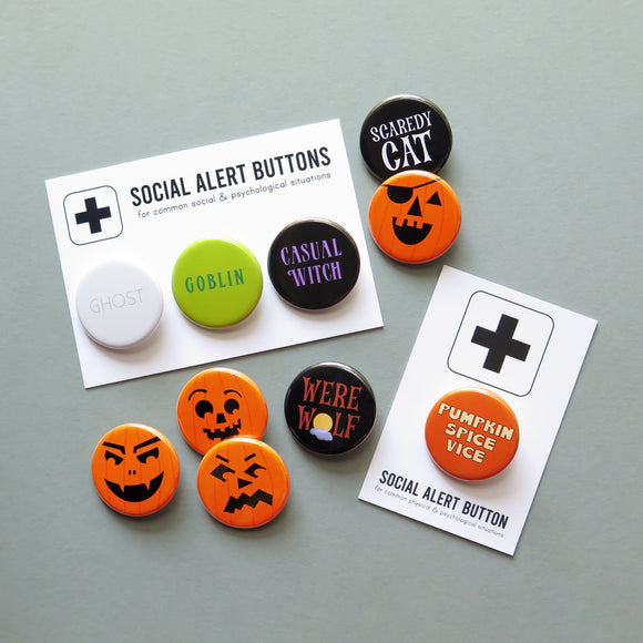 A group of five Halloween and fall themed buttons