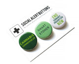 Three round pinback buttons in different shades of green, lined up on a SOCIAL ALERT BUTTONS backing card. Reading left to right: Cannabis Connoisseur, Smart Stoner, End Cannabis Prohibition Now!