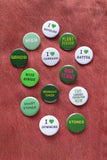 A bunch of cannabis weed themed small round pinback buttons pinned to orange denim, with phrases reading: Midnight Tower, Medicated, High, Stoned, Smart Stoner, High Femme, Weed Genius, I Love Sativa, Love Edibles, I Love Gummies, Plant Person and more.