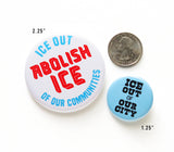 A medium size 2.25" pinback button, a small 1.25" pinback button and a quarter coin to show size relationships. 