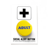 Round pinback button that says ADULT. Blue text on a yellow background. The button is pinned to a Social Alert Button backing card.