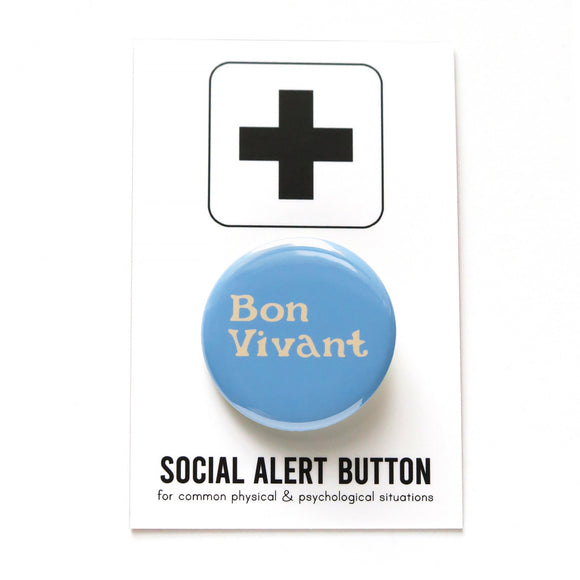 Round, light blue pinback button with cream text that reads BON VIVANT on two lines. Pinned to a Social Alert Button backing card.