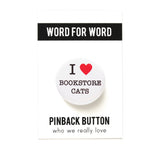  round white 1.25" pinback button that reads I LOVE BOOKSTORE CATS, love being represented by a red heart. Button is pinned to a Word For Word, What We Really Love branded backing card.