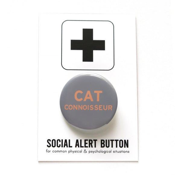 Round gray pinback button that reads CAT CONNOISSEUR in peach text. Button is on a SOCIAL ALERT BUTTON backing card.