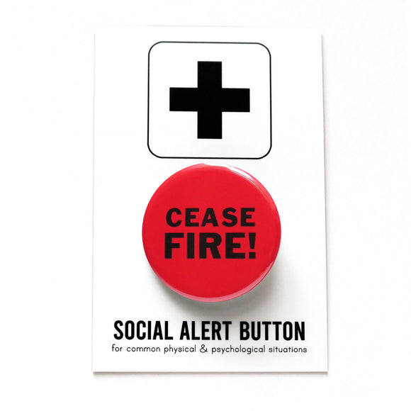 A round red pinback button that reads CEASE FIRE! in two lines in black text. The pinback button is attached to a SOCIAL ALERT BUTTON backing card.