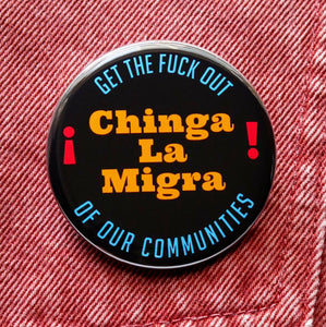 A round black pinback button that reads CHINGA LA MIGRA in goldenrod text And Get The Fuck Out, Of Our Communities in blue text rounded at the top and bottom of the button.  Badge is pinned to orange denim.