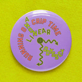 Big 3 inch round lavender pinback button with neon green & coral text laid out like a sick squiggly clock that reads RUNNING ON CRIP TIME, with ON Bisected with A Non Linear Odyssey. Button is on a neon yellow green sweatshirt.