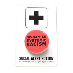 Round pinback button that says DISMANTLE SYSTEMIC RACISM. Black text on a neon red background. Button is pinned to a Social Alert Button backing card