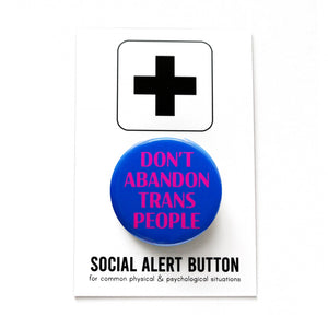 A round blue pinback button that reads DONT ABANDON TRANS PEOPLE in magenta pink. The button is held in a hand.