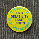 Round neon lime yellow 2.25" pinback button that reads PEND DISABILITY ASSET LIMITS in the center, purple text and. Forced Poverty s Cruel & Inhumane is along the top, and bottom. Pinned to black denim.