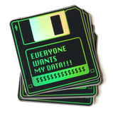 A stack of black & green holographic stickers that look like a 1990's little hard floppy disc that reads EVERYONE WANTS MY DATA !!! with a strip of dollar signs where a label would be.