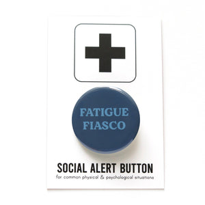 A deep muted blue pinback button that reads FATIGUE FIASCO in a lighter blue. Button is on a SOCIAL ALERT BUTTON backing card.