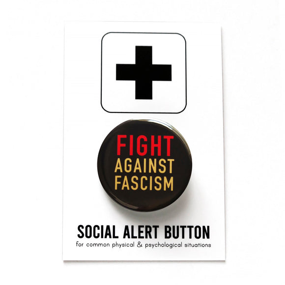 A round black pinback button that reads FIGHT AGAINST FASCISM in three lines in red and cream text. The pinback button is attached to a SOCIAL ALERT BUTTON backing card. 