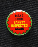 Round  & orange 1.25"  pinback button that reads MAKE FOOD SAFETY INSPECTED AGAIN in black and yellow text.  Badge is pinned to black denim.