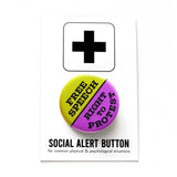 A round purple & lime green pinback button split down the middle. The green top half reads FREE SPEECH, the blue lower half reads RIGHT TO PROTES. Button is pinned to a SOCIAL ALERT BUTTON backing card.