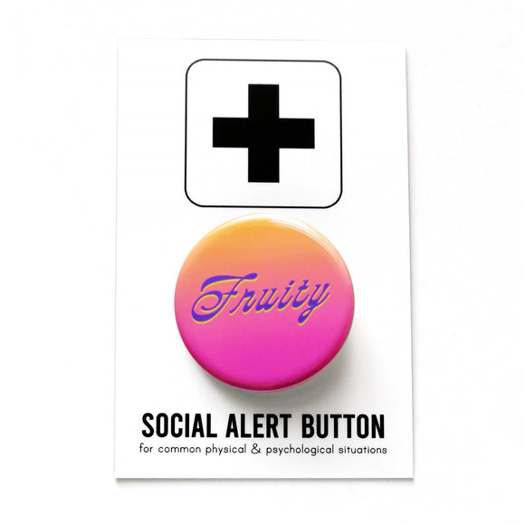 A peach to pink ombre pinback button that reads FRUITY in a purple scripty font with a slight neon yellow drop shadow. Badge is on a white backing card that reads SOCIAL ALERT BUTTON in black text.