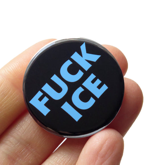 a round black button that says FUCK ICE in a chunky light blue font. Badge is held in a hand.