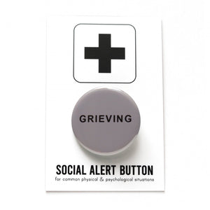 Round dark grey button that reads GRIEVING in black san serif text. Badge is on a Social Alert Button backing card.
