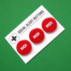 3 round red pinback buttons lined up on a SOCIAL ALERT BUTTONS backing card. Reading left to right: Ho! Ho! Ho! Buttons are on a festive green background, giving a silly christmas vibe