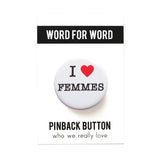 A round white pinback button that reads I LOVE FEMMES in a black serif font, the love being indicated by a red heart. Button is on a Word For Word branded card, reading Pinback Button, Who We Really Love.