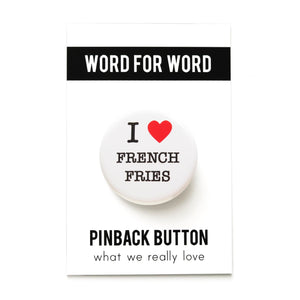 A round white button that reads I LOVE FRENCH FRIES. Love being represented by a red heart. Button is pinned to a Word For Word branded backing card.