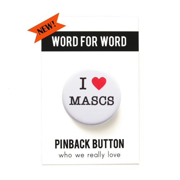 A round white pinback button that reads I LOVE MASCS in a black serif font, the love being indicated by a red heart. Button is on a Word For Word branded card, reading Pinback Button, Who We Really Love.