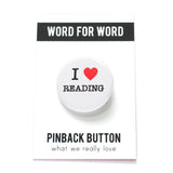 A round white pinback button that reads I LOVE READING, love being represented by a red heart. Button is pinned to a Word For Word, What We Really Love branded backing card.