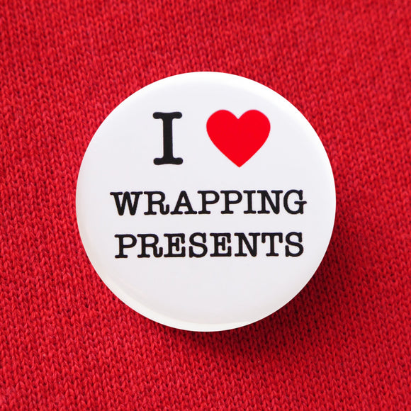 Round, white pinback button that says I LOVE WRAPPING PRESENTS in classic black text with 
