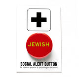 Round red pinback button reads JEWISh in light green text, on SOCIAL ALERT BUTTON backing card.