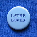 round light blue 1.25" pinback button that reads LATKE LOVER in dark blue serif text.  Button is pinned to a blue sweatshirt