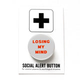 Round, light grey button with red & orange text reading LOSING MY MIND. Badge on a Social Alert Button backing card.