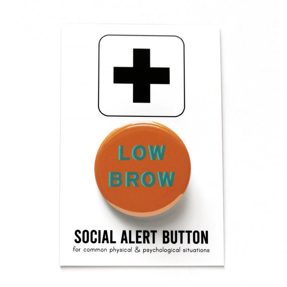 Round milk chocolate brown pinback button with aqua teal text that reads LOW BROW. Badge is on a Social Alert Button backing card.