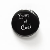 Black round pinback button that reads LUMP OF COAL in white old fashioned font.