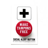 A round red 1.25" pinback button that reads MAKE TAMPONS FREE in a white fonts. Button is on a Social Alert Button backing card.