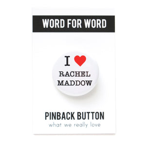 Round white pinback button that reads I LOVE RACHEL MADDOW, with love being represented by a red heart. Button is on a branded Word For Word backing card.