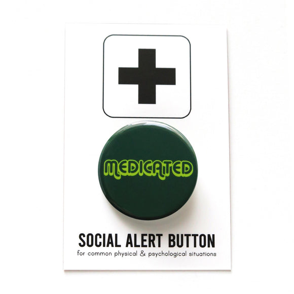 Round dark green button that reads MEDICATED in a neon green font. Badge is on a Social Alert Button backing card.
