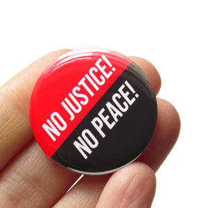 A round pinback button split half red, half black. The top red reads No Justice, bottom black reads NO PEACE! Button is held in a hand.