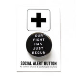 Round black pinback button that reads OUR FIGHT HAS JUST BEGUN in white text. Button is on a Social Alert Button backing card.
