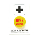 Round yellow pinback button that reads OVER WORKED in red text. OVER is bigger. Badge is on a Social Alert Button backing card.