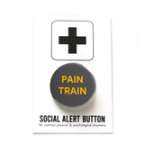 Round gray pinback button that reads PAIN TRAIN in yellow text. Button is on a Social Alert Button backing card.