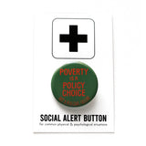 a round dark green pinback buton that reads POVERTY IS A POLICY CHOICE, Not a Personal Failure in orange text. Button is pinned to a Social alert Button backing card