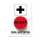 A round bright red pinback button that reads RESIST in black type. Button is on a SOCIAL ALERT BUTTON backing card.