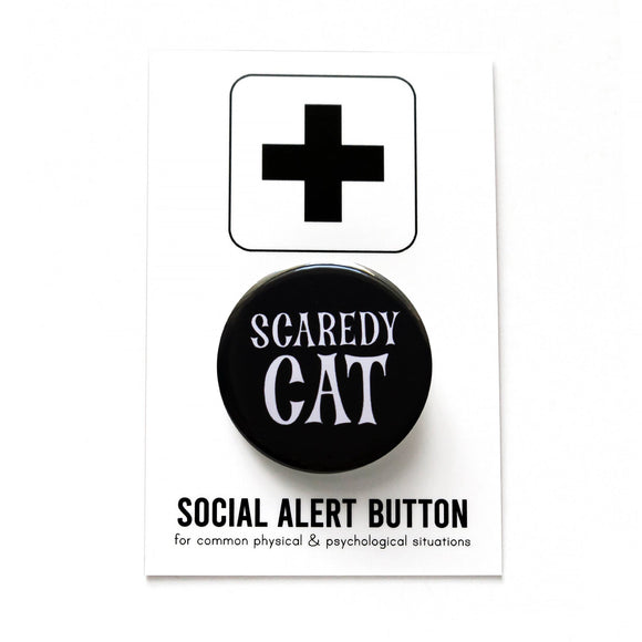 A round black pinback button that reads SCAREDY CATin a spooky white font. Button is on a white backing card with a black plus sign at the top, reading Social Alert Button at the bottom.