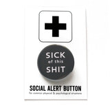 Round, dark gray pinback button that reads SICK OF THIS SHIT in white text. Pinned to a Social Alert Button Backing Card.