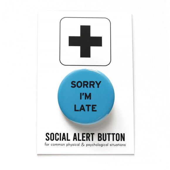 Round medium blue pinback button that reads SORRY I'M LATE in black text. Pinned to a Social Alert Button backing card.
